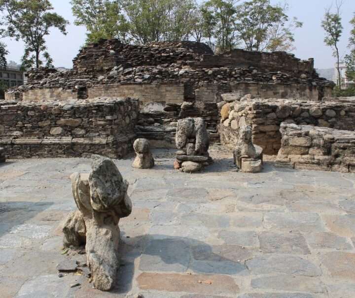 Ruins of an ancient Buddhist site in the Gandhara region, featuring weathered stone structures and remnants of sculptures.