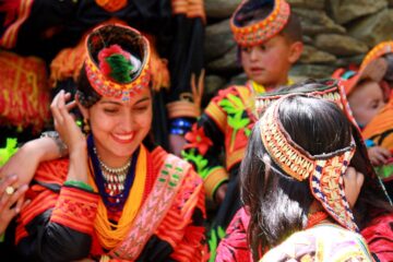 Kalash women and children dressed in traditional attire, celebrating a cultural festival in Pakistan.