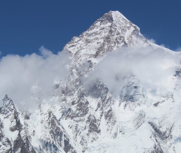 Majestic view of K2, the second-highest mountain in the world, covered in snow with a clear blue sky.